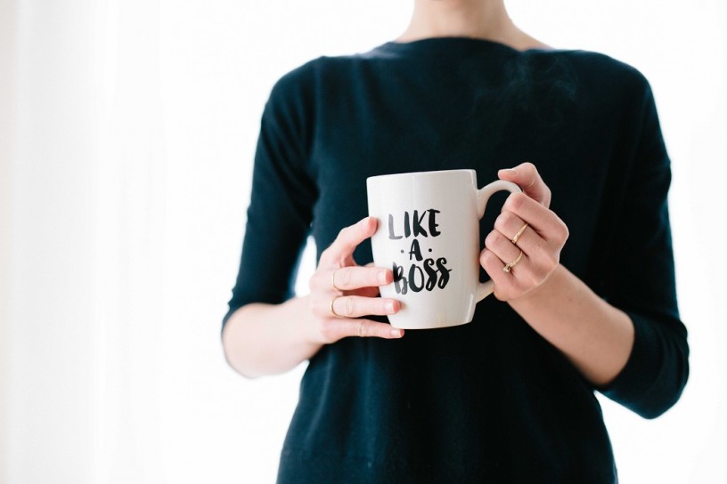 female entrepreneur holds mug with words like a boss